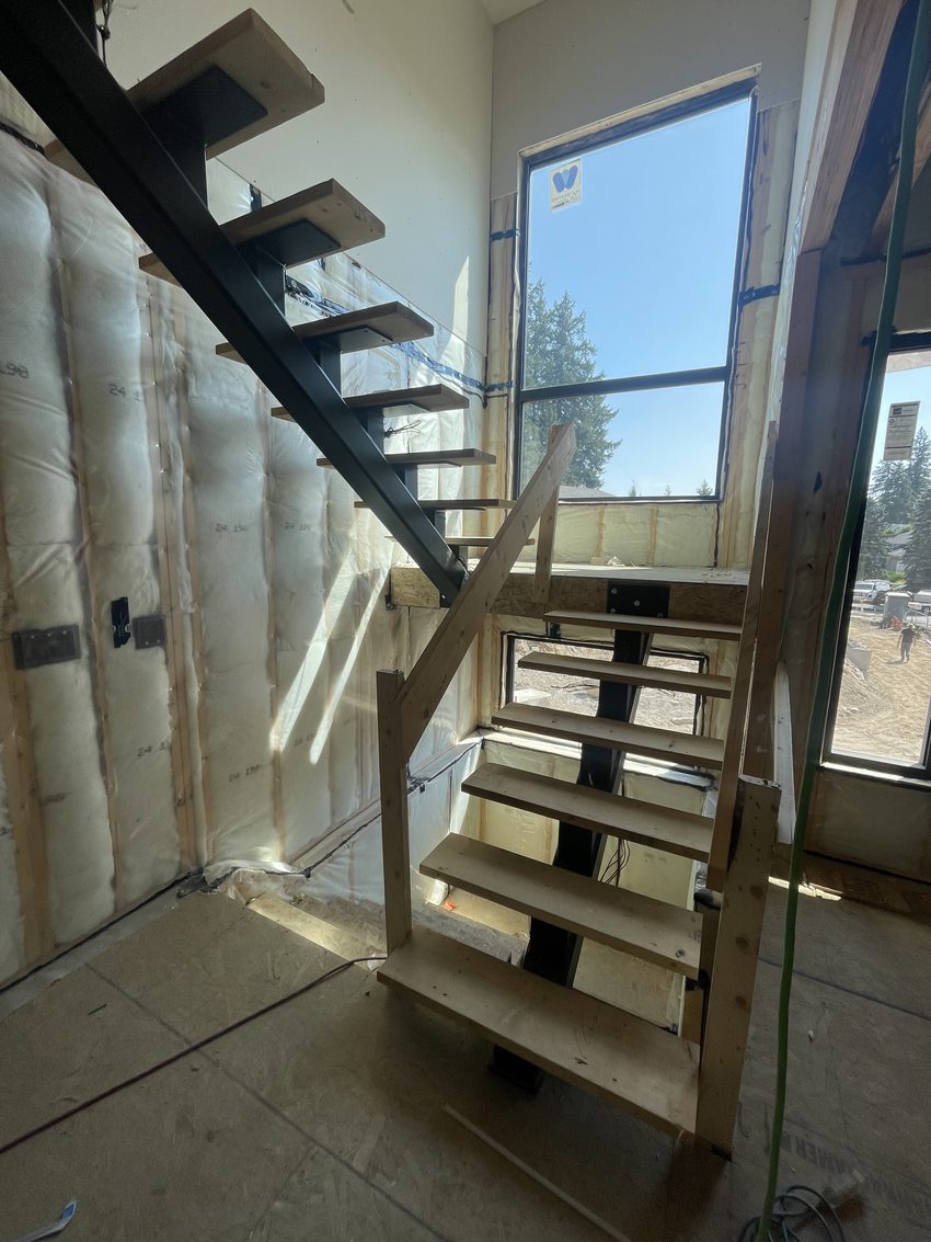 Steel-stringer floating staircase framed inside a home under construction